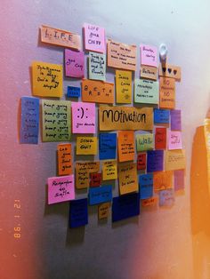 colorful sticky notes attached to the side of a wall with words written on them and magnets