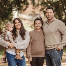 a family posing for a photo in front of some trees