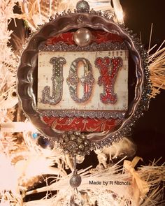 a christmas ornament with the word joy hanging from it's centerpiece