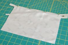 a piece of white fabric sitting on top of a cutting mat