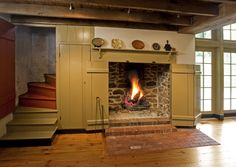 a fire place in the middle of a living room with stairs leading up to it