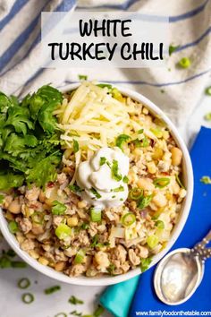 white turkey chili in a bowl with sour cream and cilantro garnish