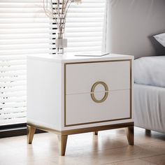 a white and gold nightstand with flowers on it