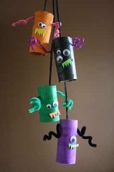 some paper bags are hanging from a wire with monster faces on them, and one has eyes