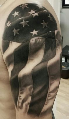 an american flag tattoo on the back of a man's left arm and shoulder