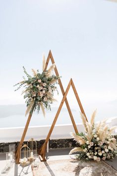 an outdoor ceremony setup with flowers and greenery