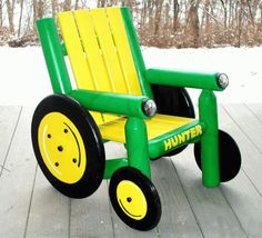 a green and yellow plastic chair sitting on top of a wooden deck in the snow