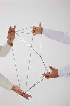 three people holding strings in their hands and pulling them apart from each other with one hand