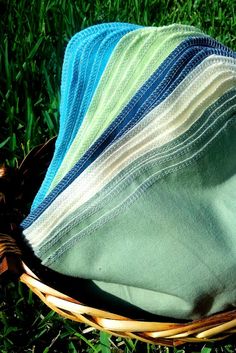 a basket filled with lots of blankets on top of a grass covered field in the sun