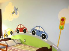 a child's bedroom with cars painted on the wall and bed in the foreground