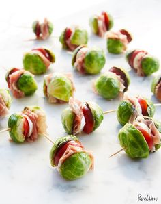 small appetizers with meat, cheese and lettuce are arranged on a white surface