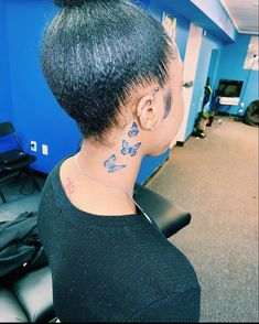 the back of a woman's head with tattoos on her neck and behind her ear