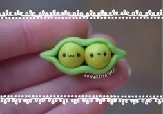 two peas in a pea pod shaped brooch with eyes drawn on it's side