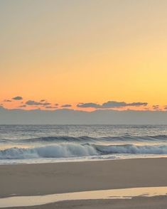 two surfers walking on the beach at sunset