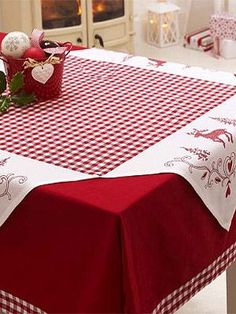 a red and white table cloth with christmas decorations on it