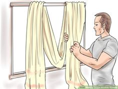 a man is opening curtains in front of a window