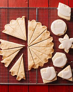 some cookies are sitting on a cooling rack with white icing and other food items