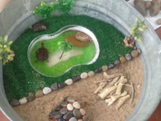 a bowl filled with rocks and plants on top of a table