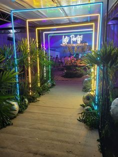 an entrance to a hotel with plants and lights on the walkway leading up to it