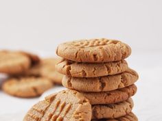 a stack of peanut butter cookies sitting on top of a white table next to each other