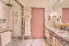 a bathroom with marble counter tops and pink doors