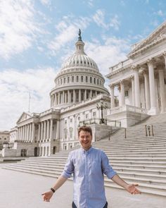 a man standing in front of the capital building with his hands out and arms wide open