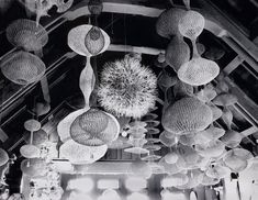 an old black and white photo of many hanging baskets in a room with wood floors