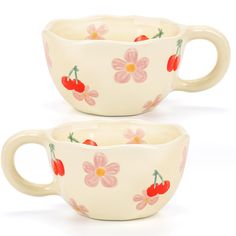 two cups with cherries and flowers painted on them