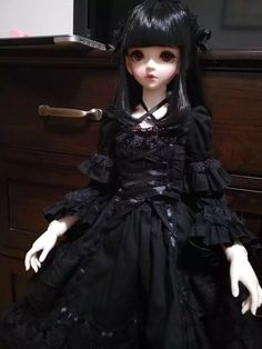 a doll sitting on top of a wooden dresser