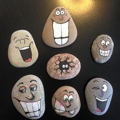 some rocks with different faces painted on them