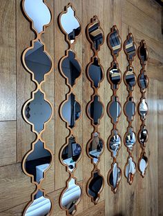 a wooden wall with many mirrors hanging on it