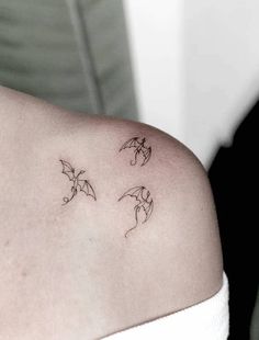 a woman's shoulder with three small bats on it