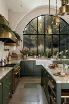 a kitchen filled with lots of green cabinets and counter top next to a large window