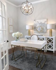 a white table with two chairs and a chandelier