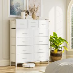 a white dresser sitting next to a bed in a bedroom