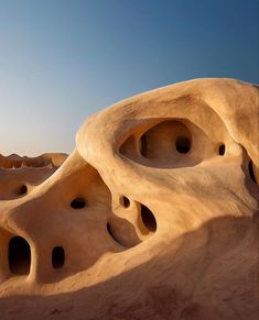 an unusual rock formation in the desert with holes carved into it's walls and sides