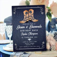 a blue and gold cowboy boots birthday party with pink flowers on the table in front of it