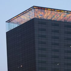 an airplane is flying in the sky near a building with a large window on top