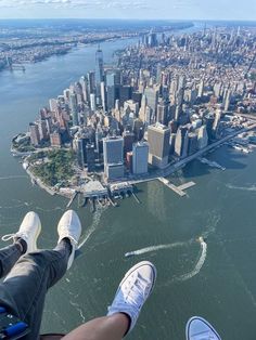 two people standing on the edge of a high rise looking down at a large city