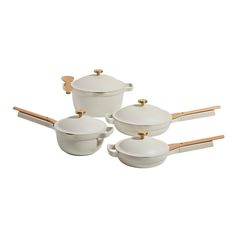 four white pots and pans with wooden handles on a white background, set of three