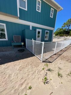 a blue house with a white fence around it