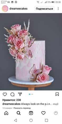 a pink cake with flowers on top and some words above it that read dreamcakes