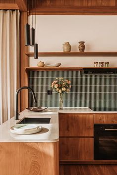 a kitchen with wooden cabinets and white counter tops, along with an open shelf above the sink