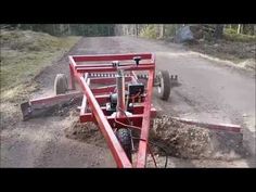 a tractor pulling a trailer down a dirt road