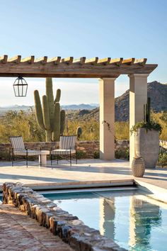 an outdoor patio with a pool and cactus