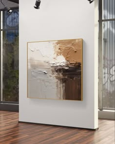 an abstract painting hangs on the wall next to a wooden floor in front of a large window