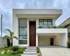 a modern house with grass and plants in front