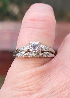 a woman's hand with a diamond ring on top of her finger and an engagement band