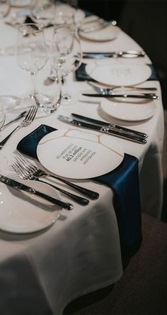 the table is set with white plates and silverware