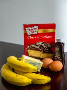 bananas, eggs, and cheese are sitting on a table next to an egg carton